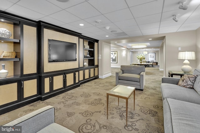 living room featuring a paneled ceiling, carpet, and built in features