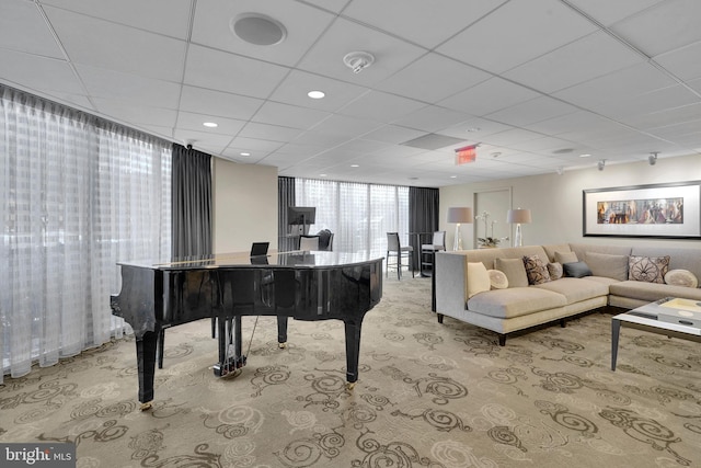 miscellaneous room with a paneled ceiling, expansive windows, and light carpet