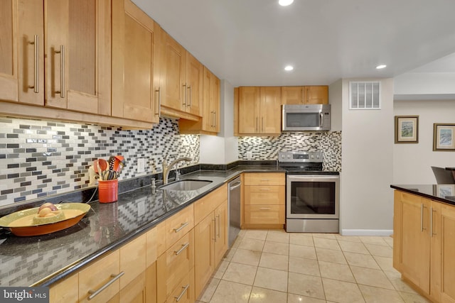 kitchen with stainless steel appliances, backsplash, sink, and light tile patterned floors