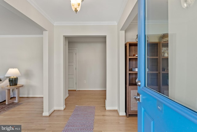 foyer featuring light wood finished floors, baseboards, and ornamental molding