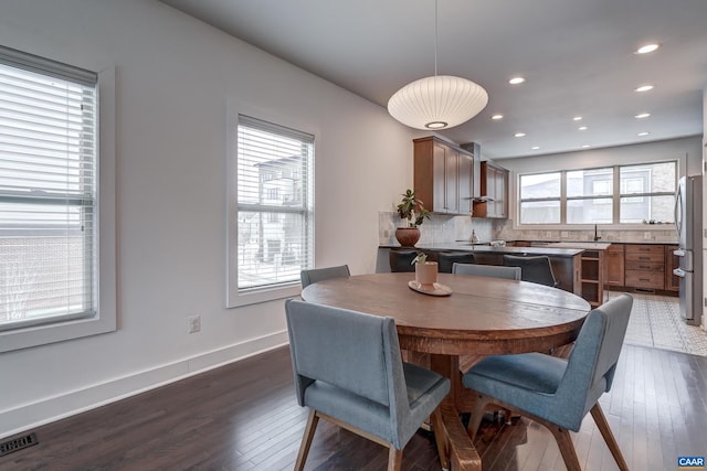 dining space with wood-type flooring and sink