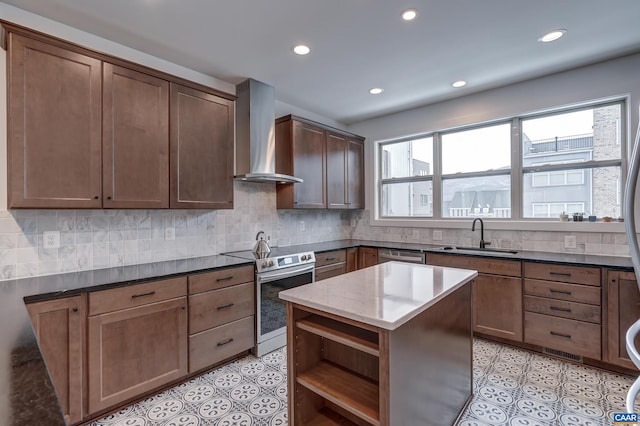 kitchen with wall chimney exhaust hood, a kitchen island, dark stone counters, appliances with stainless steel finishes, and sink