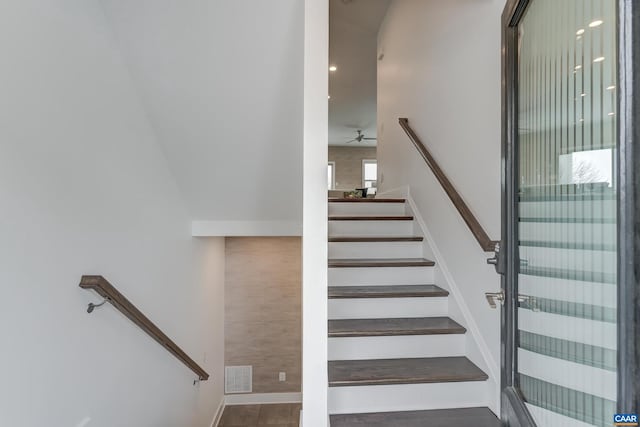 stairway with ceiling fan and tile patterned floors