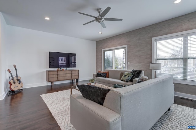 living room featuring ceiling fan and dark hardwood / wood-style floors