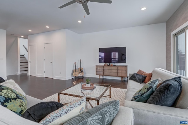 living room with ceiling fan and dark wood-type flooring