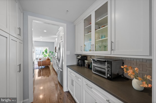 kitchen featuring backsplash, stainless steel fridge, dark hardwood / wood-style flooring, and white cabinetry