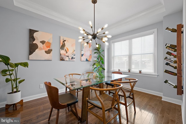 dining room with a raised ceiling, a notable chandelier, crown molding, and dark hardwood / wood-style floors