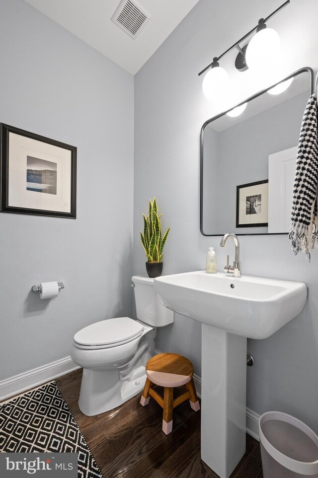 bathroom with toilet, sink, and hardwood / wood-style flooring