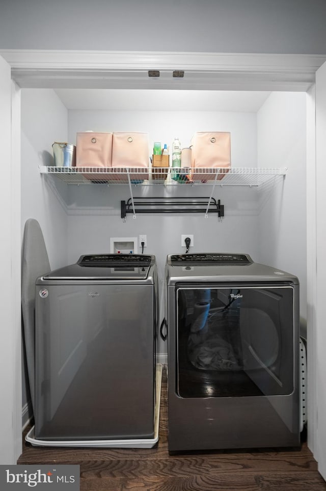 clothes washing area with dark wood-type flooring and washer and dryer