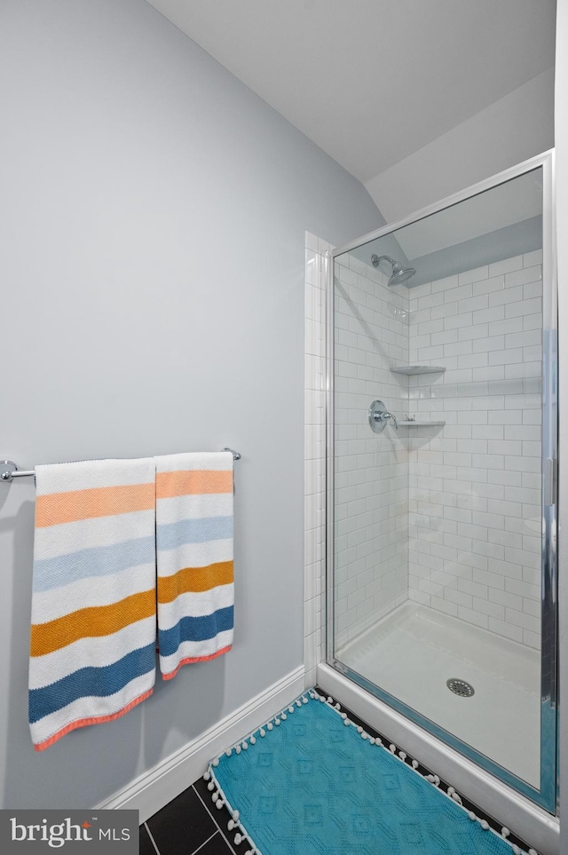 bathroom with tile patterned flooring and a tile shower