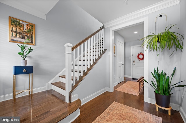 entrance foyer with ornamental molding and dark hardwood / wood-style floors