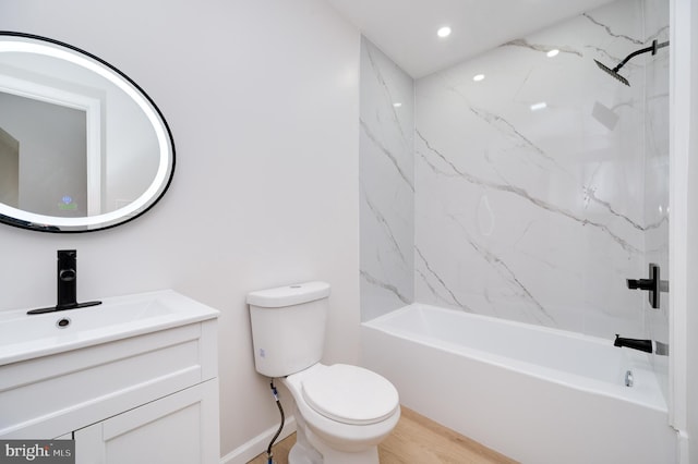 full bathroom with toilet, hardwood / wood-style flooring, tiled shower / bath, and vanity