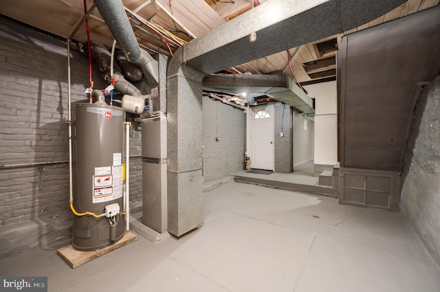 basement featuring heating unit, water heater, and brick wall