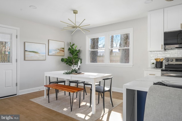 dining space with a notable chandelier and hardwood / wood-style flooring