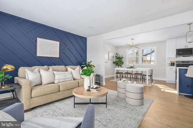 living room with a notable chandelier and light wood-type flooring