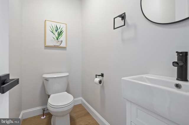 bathroom featuring toilet, wood-type flooring, and sink