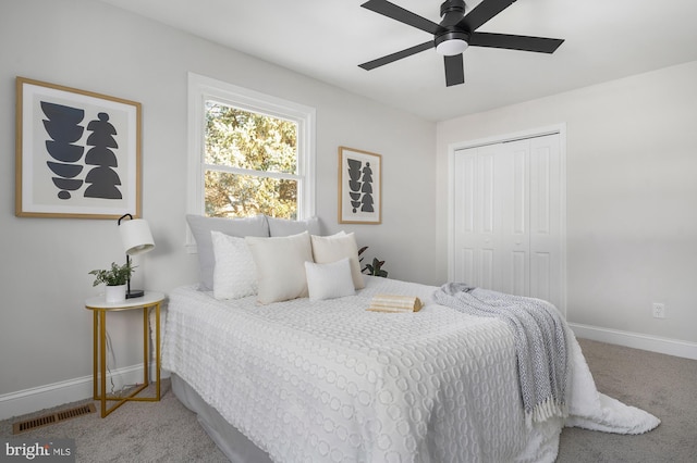 carpeted bedroom featuring ceiling fan and a closet