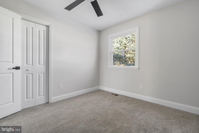 unfurnished bedroom featuring ceiling fan, a closet, and carpet floors