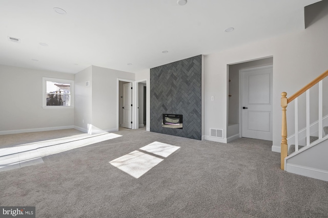 unfurnished living room featuring light colored carpet and a tiled fireplace