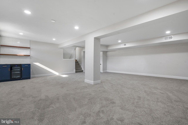 basement featuring light colored carpet and beverage cooler