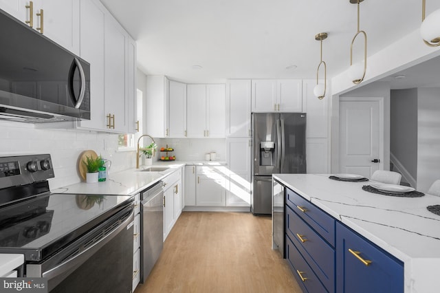 kitchen featuring white cabinetry, appliances with stainless steel finishes, blue cabinets, hanging light fixtures, and sink