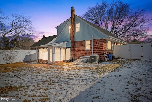 snow covered property with central AC