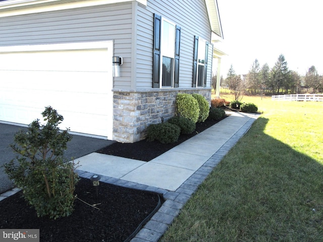 view of property exterior featuring a yard and a garage