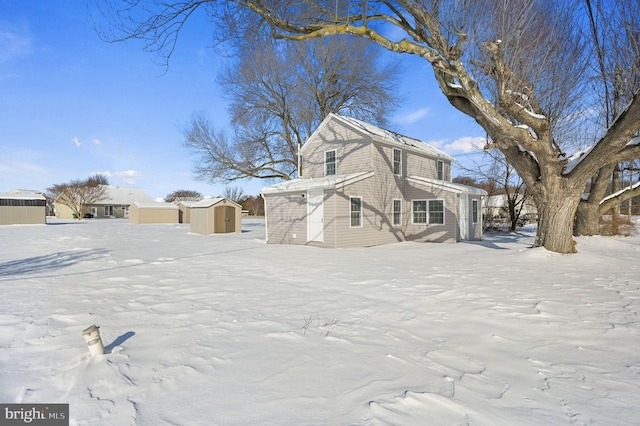 view of snow covered exterior with a shed