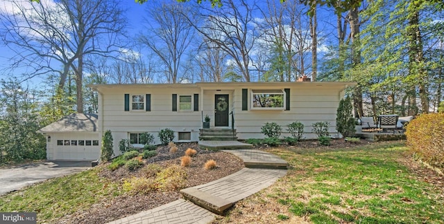 view of front of property with driveway, a chimney, and an attached garage