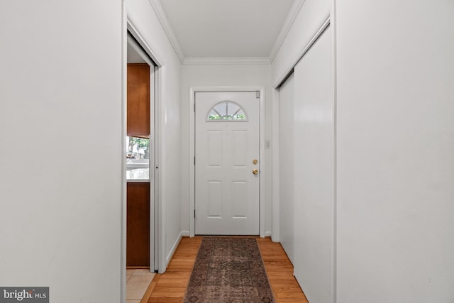 doorway with light wood-style floors and crown molding