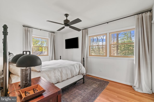 bedroom featuring light wood-type flooring, ceiling fan, and baseboards