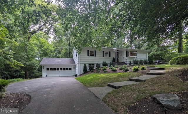 view of front of house with a front lawn, an attached garage, and aphalt driveway