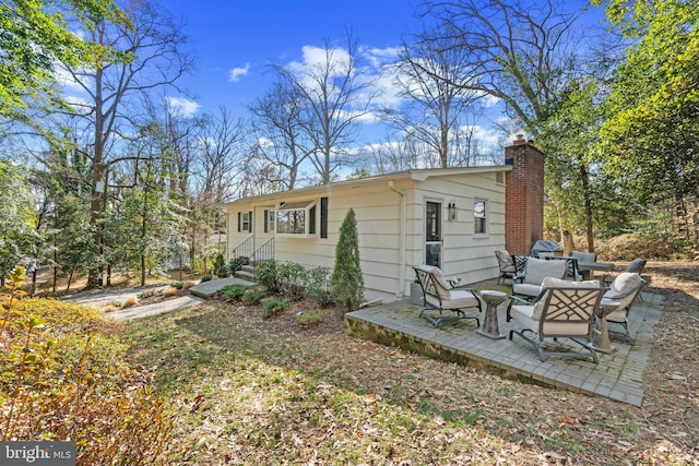 rear view of property with an outdoor hangout area, a patio, and a chimney