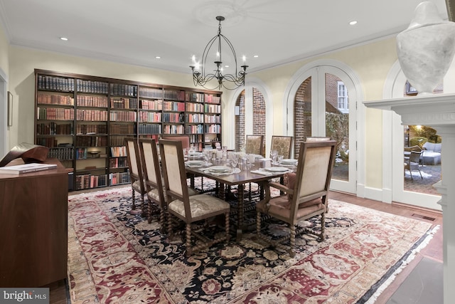 dining area featuring a chandelier, crown molding, and hardwood / wood-style flooring