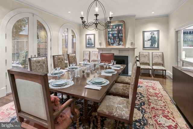 dining area featuring wood-type flooring, french doors, crown molding, and a notable chandelier