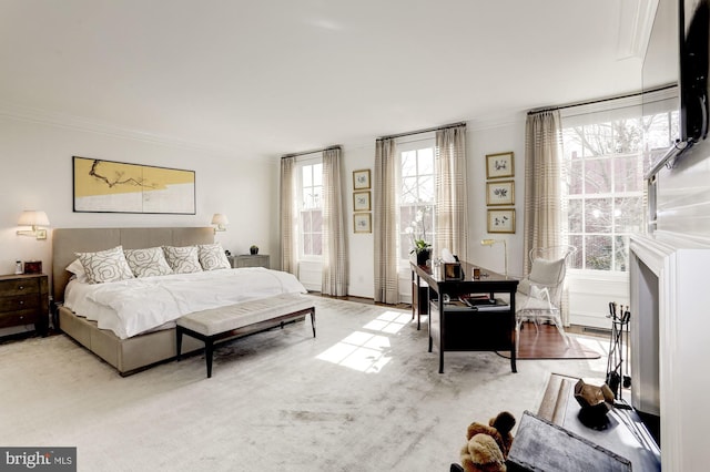 bedroom with ornamental molding and light colored carpet