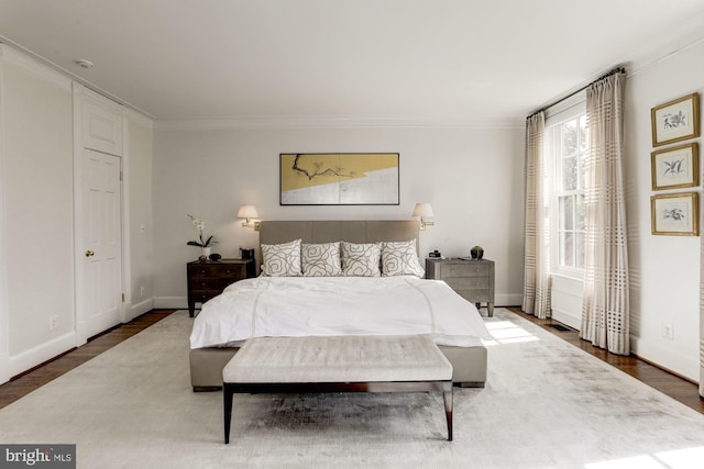 bedroom with dark hardwood / wood-style floors and crown molding