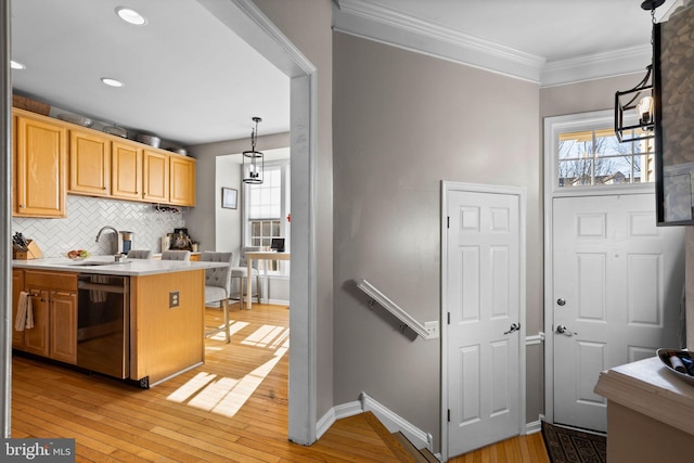 kitchen with sink, hanging light fixtures, black dishwasher, backsplash, and light wood-type flooring