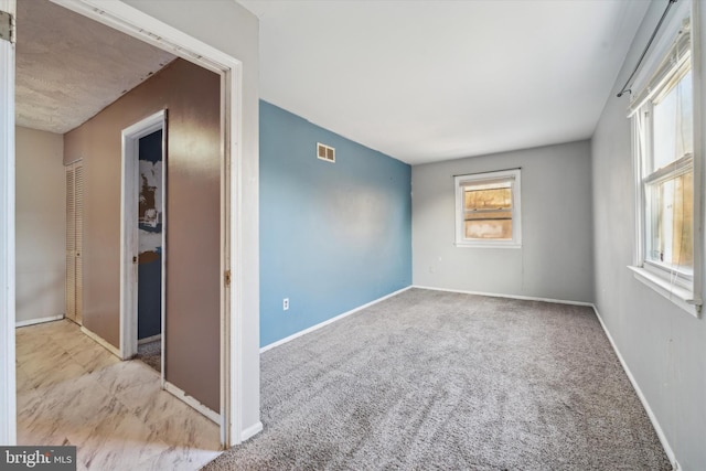 empty room featuring light carpet and a healthy amount of sunlight