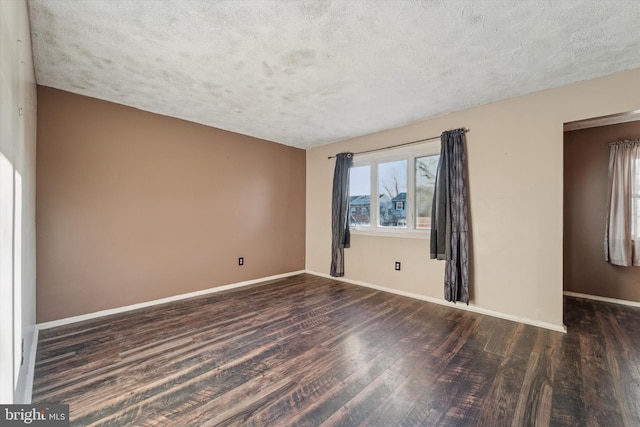 empty room with dark wood-type flooring and a textured ceiling