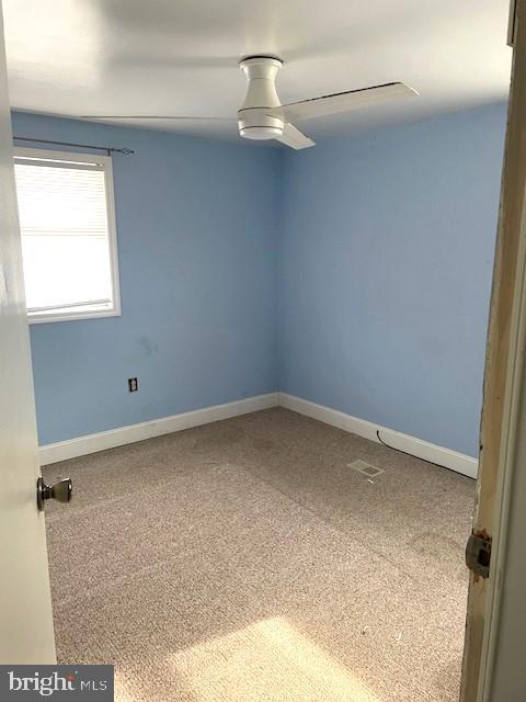 empty room with ceiling fan and carpet