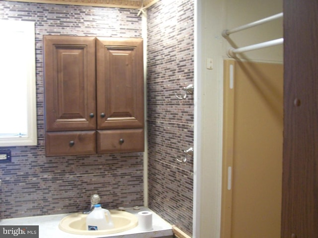 bathroom featuring tasteful backsplash and sink