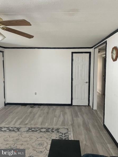 empty room featuring hardwood / wood-style flooring, ceiling fan, and ornamental molding