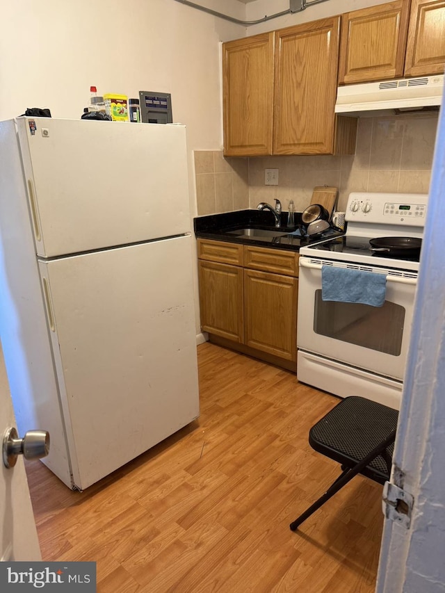 kitchen featuring backsplash, sink, white appliances, and light wood-type flooring