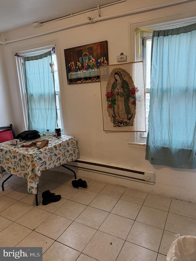 tiled dining space featuring a baseboard heating unit