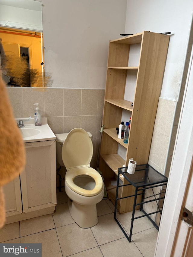 bathroom with tile patterned flooring, vanity, toilet, and tile walls