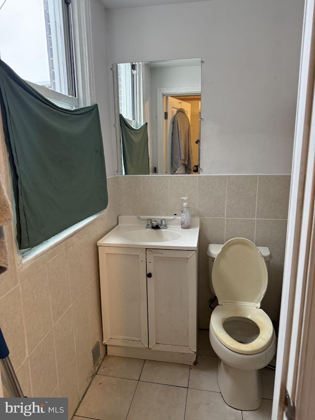 bathroom featuring tile patterned flooring, vanity, toilet, and tile walls