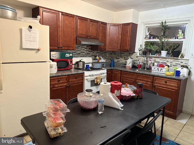 kitchen featuring white appliances, sink, decorative backsplash, light tile patterned floors, and extractor fan