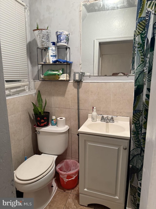 bathroom featuring tile patterned flooring, vanity, toilet, and tile walls