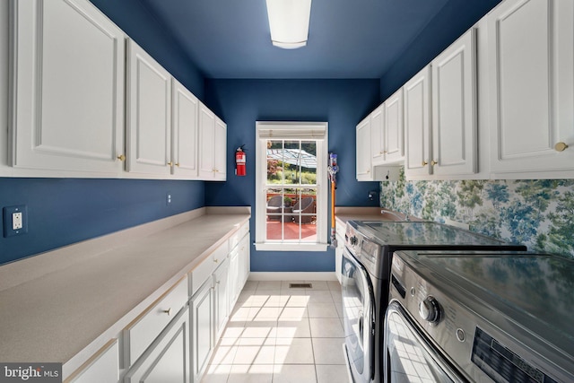 laundry room featuring cabinets, washer and clothes dryer, and light tile patterned floors